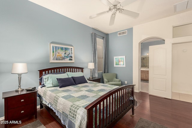 bedroom with visible vents, arched walkways, baseboards, and wood finished floors