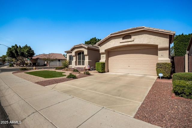 mediterranean / spanish-style home with stucco siding, an attached garage, driveway, and a tile roof