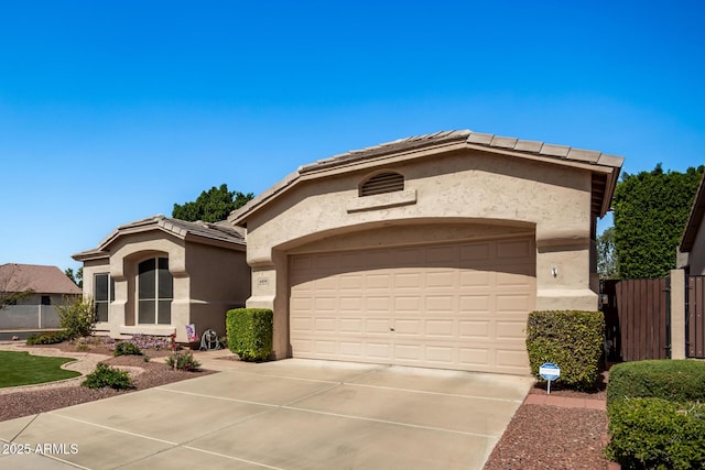 view of front facade with a tiled roof, stucco siding, an attached garage, and concrete driveway