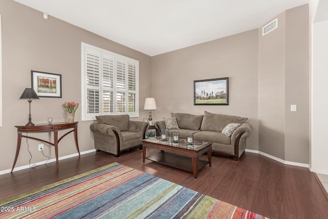 living area featuring wood finished floors, visible vents, and baseboards