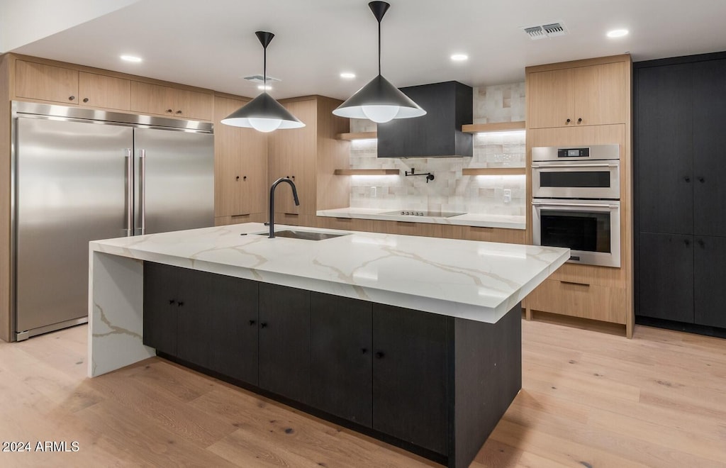 kitchen with a sink, visible vents, appliances with stainless steel finishes, open shelves, and light wood finished floors