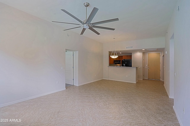 unfurnished living room with ceiling fan and baseboards