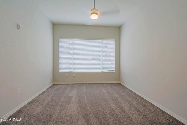 carpeted spare room featuring baseboards