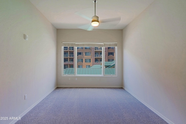 spare room with a ceiling fan, carpet floors, and baseboards