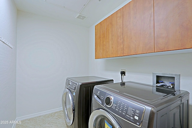 clothes washing area featuring cabinet space, washer and dryer, and baseboards