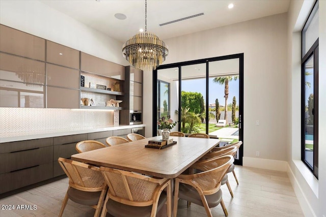 dining space featuring a chandelier, light hardwood / wood-style floors, and a healthy amount of sunlight