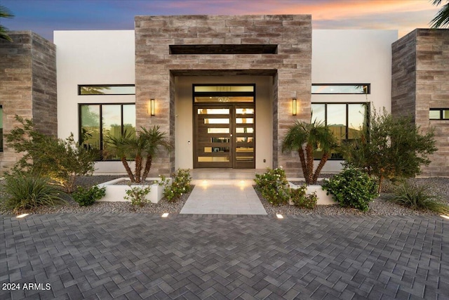 exterior entry at dusk featuring french doors