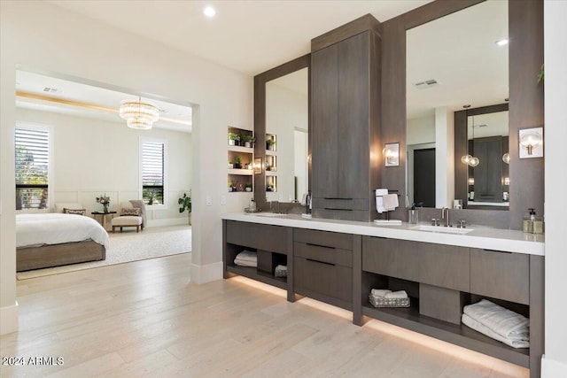 bathroom featuring hardwood / wood-style floors, a notable chandelier, and vanity