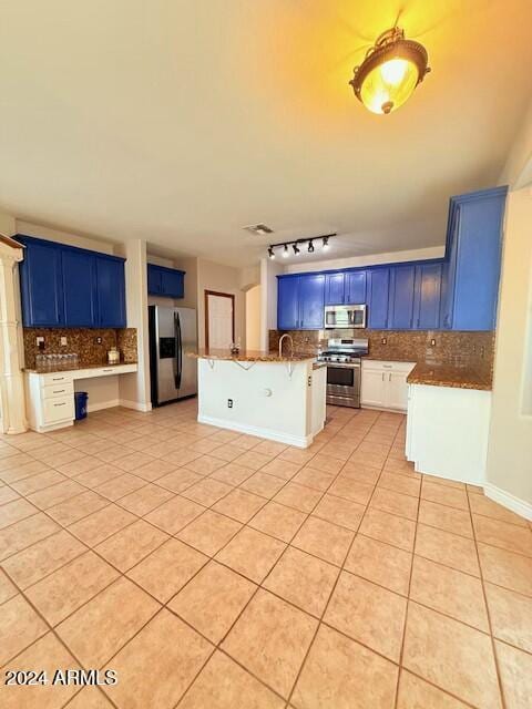 kitchen with stainless steel appliances, tasteful backsplash, blue cabinets, and light tile patterned floors