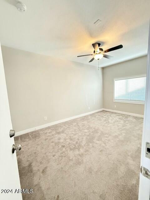 empty room featuring ceiling fan and carpet flooring