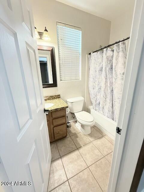 full bathroom with tile patterned flooring, vanity, shower / bath combo, and toilet