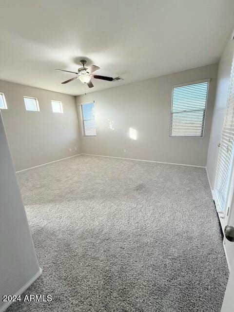 carpeted spare room with ceiling fan