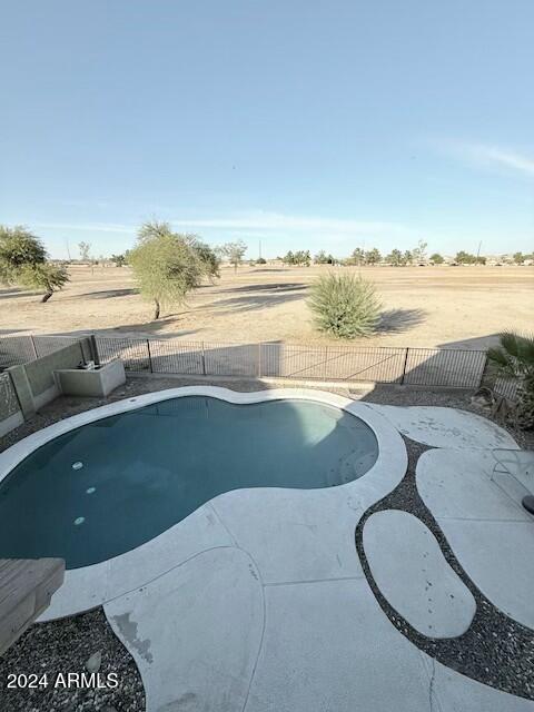 view of swimming pool featuring a rural view and a patio