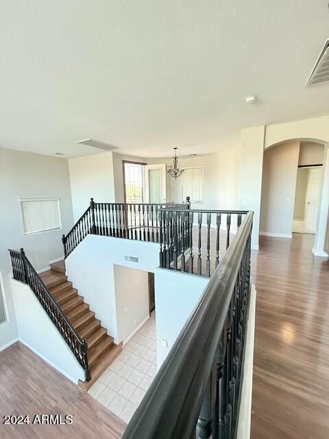 staircase featuring hardwood / wood-style floors and a chandelier