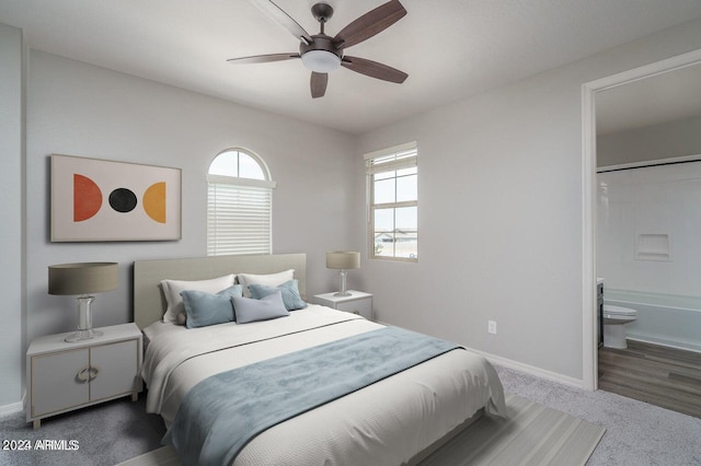 carpeted bedroom with connected bathroom and ceiling fan