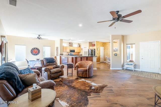 living room with light hardwood / wood-style floors and ceiling fan