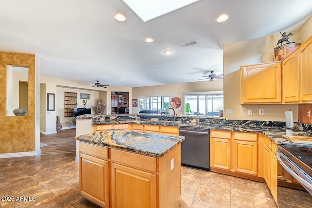 kitchen featuring kitchen peninsula, ceiling fan, appliances with stainless steel finishes, sink, and a kitchen island