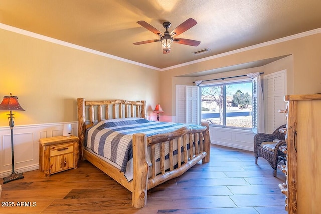 bedroom with crown molding, hardwood / wood-style flooring, a textured ceiling, and ceiling fan