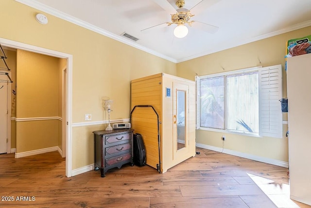 bedroom featuring light hardwood / wood-style flooring, ceiling fan, and ornamental molding