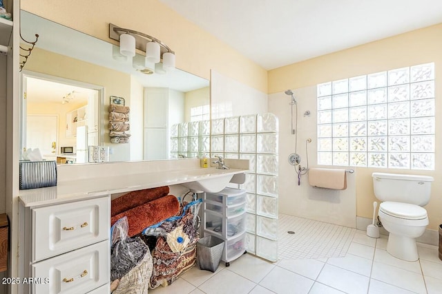 bathroom featuring sink, toilet, tile patterned flooring, and walk in shower