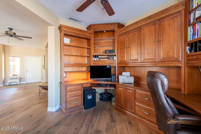 office with hardwood / wood-style floors, ceiling fan, and built in desk