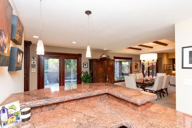 kitchen with beamed ceiling, pendant lighting, an inviting chandelier, and a wealth of natural light