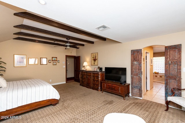 bedroom with connected bathroom, ceiling fan, beamed ceiling, and light tile patterned flooring