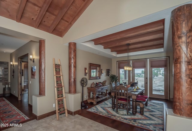 dining area with wooden ceiling, a notable chandelier, vaulted ceiling with beams, and baseboards