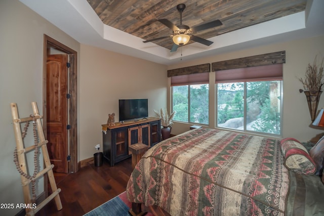 bedroom with baseboards, a raised ceiling, a ceiling fan, wood ceiling, and dark wood-style flooring