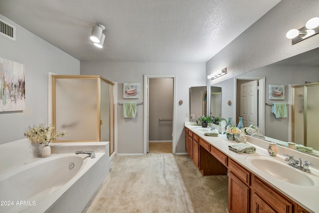 bathroom featuring a textured ceiling, vanity, and plus walk in shower