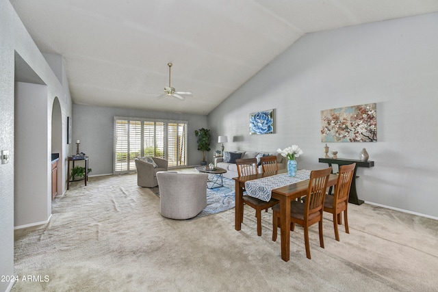 carpeted dining room featuring ceiling fan and high vaulted ceiling