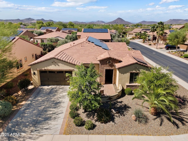 12904 W Dale Ln, Peoria, AZ 85383 - mediterranean / spanish home featuring a tiled roof, stucco siding, a residential view, solar panels, and an attached garage