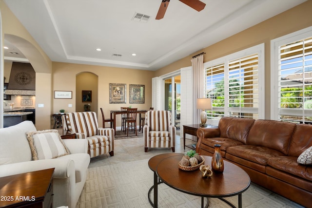 12904 W Dale Ln, Peoria, AZ 85383 - living room featuring ceiling fan, arched walkways, a raised ceiling, and recessed lighting