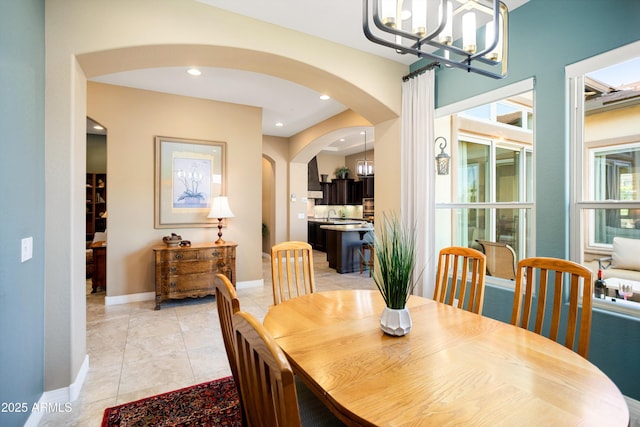 12904 W Dale Ln, Peoria, AZ 85383 - dining space featuring arched walkways, a chandelier, baseboards, light tile patterned floors, and recessed lighting