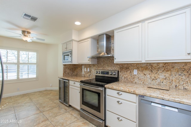 kitchen featuring stainless steel appliances, backsplash, white cabinetry, wall chimney range hood, and beverage cooler