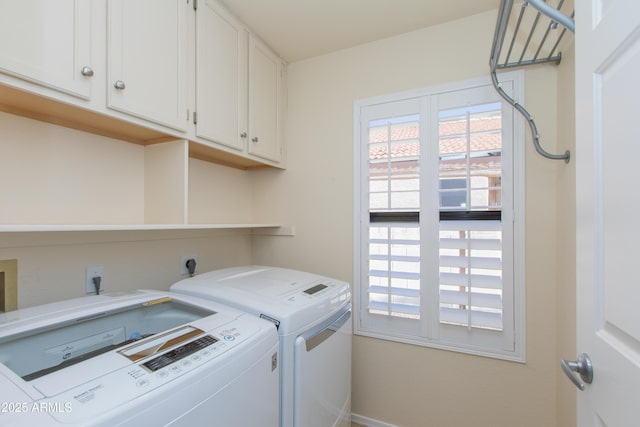 washroom with washing machine and dryer and cabinet space