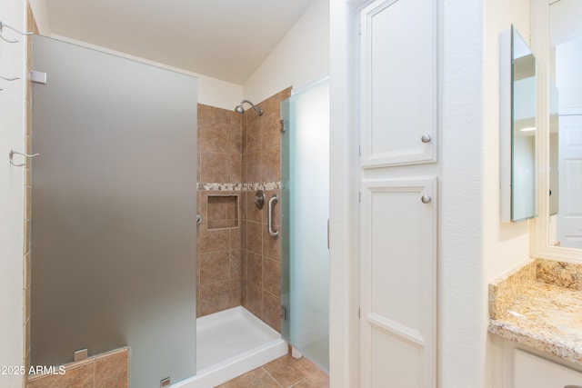 full bath with a shower stall, tile patterned flooring, and vanity