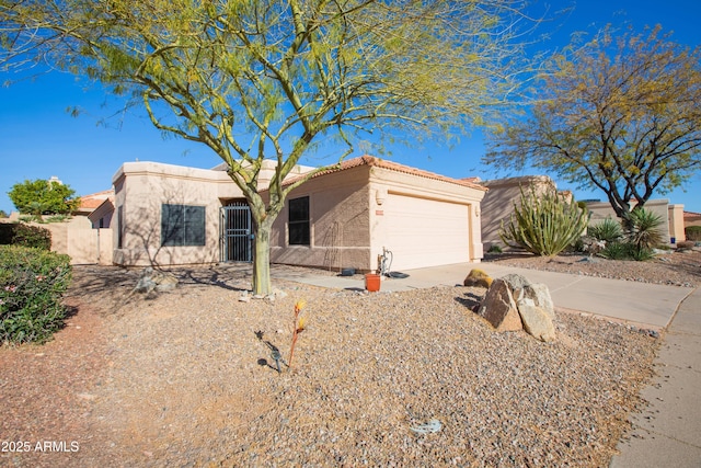 view of front of house with a garage, driveway, a tiled roof, and stucco siding