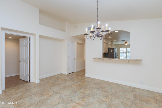 spare room with recessed lighting, baseboards, and ceiling fan with notable chandelier