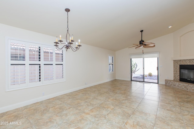 unfurnished living room featuring a glass covered fireplace, lofted ceiling, baseboards, and ceiling fan with notable chandelier