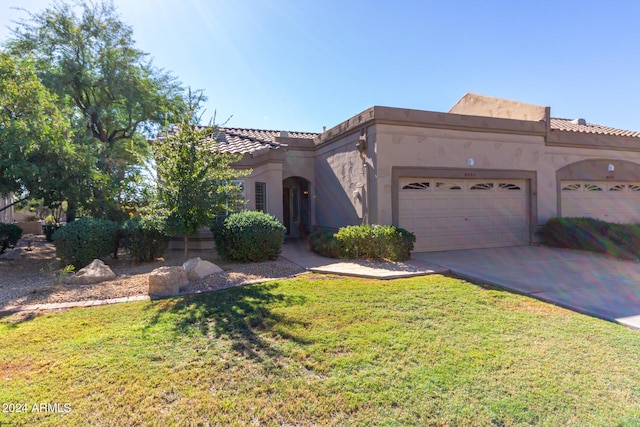 view of front of property featuring a front lawn and a garage