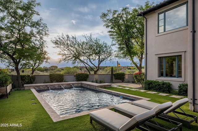 view of pool with pool water feature, a patio area, and a lawn