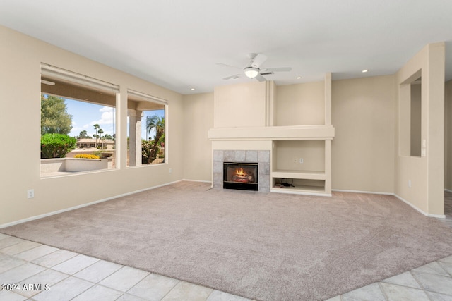 unfurnished living room with a fireplace, ceiling fan, and light tile floors