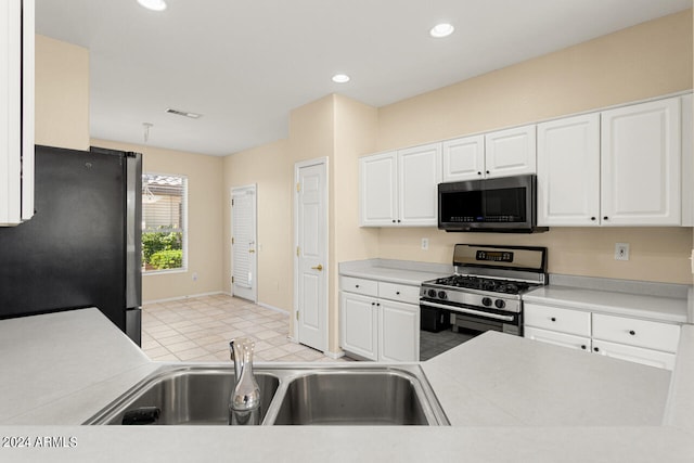 kitchen with light tile floors, stainless steel appliances, white cabinets, and sink