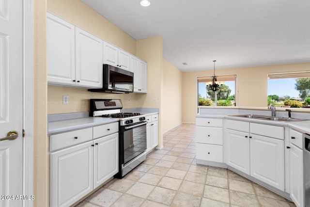 kitchen with white cabinets, sink, light tile flooring, hanging light fixtures, and range with gas stovetop