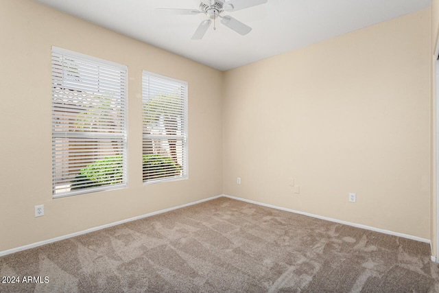 unfurnished room with a wealth of natural light, ceiling fan, and carpet floors