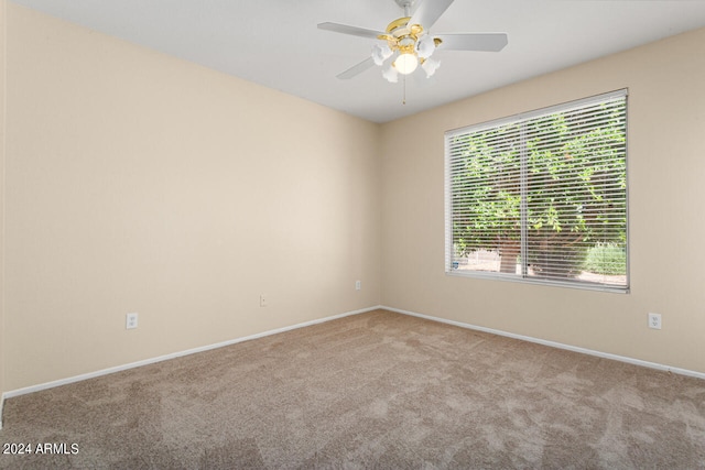 carpeted spare room featuring ceiling fan