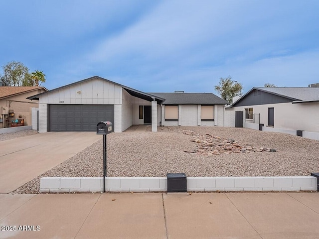 5817 S Siesta Ln, Tempe, AZ 85283 - view of front of house with driveway, an attached garage, board and batten siding, and brick siding