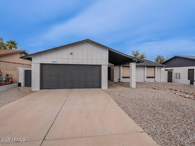 5817 S Siesta Ln, Tempe, AZ 85283 - view of front of home featuring brick siding, driveway, board and batten siding, and an attached garage