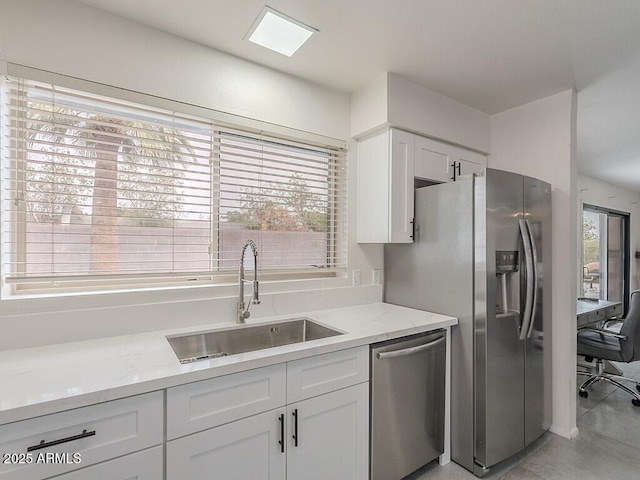 5817 S Siesta Ln, Tempe, AZ 85283 - kitchen with stainless steel appliances, a sink, white cabinets, and light stone countertops